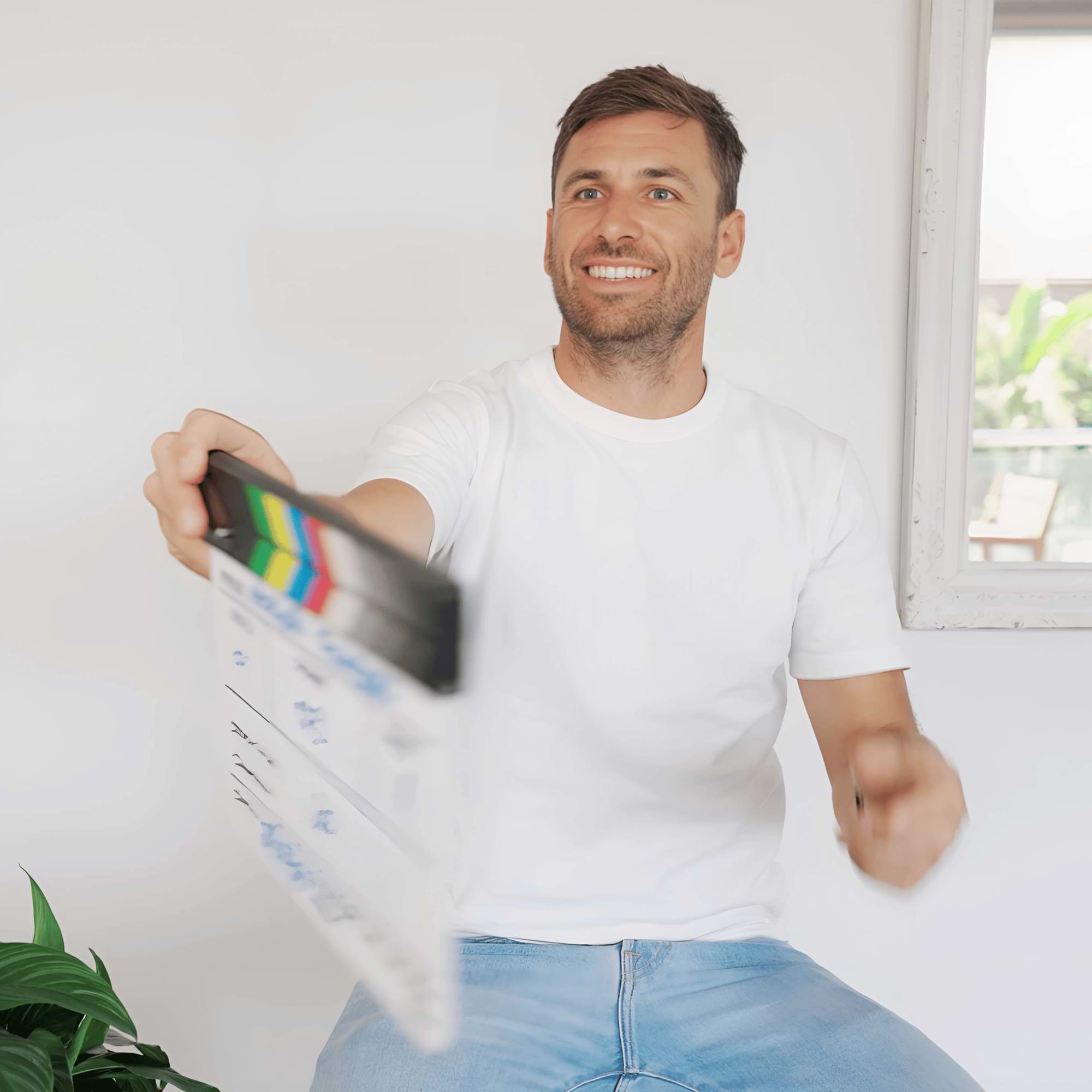 Jo holding out a clapperboard with a playful gesture.